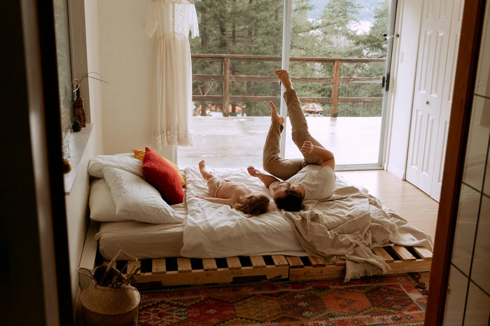 Picture of dad and kid lounging on bed